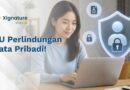 Seorang wanita menggunakan laptop dengan visualisasi perisai pelindung data personal, gembok keamanan, dan ikon privasi sebagai ilustrasi UU Perlindungan Data Pribadi.