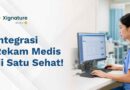 Seorang tenaga medis wanita sedang mengoperasikan komputer untuk mengelola data integrasi rekam medis elektronik pasien di rumah sakit.