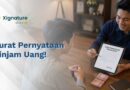 Dua orang pria sedang melakukan transaksi keuangan di mana salah satunya menunjukkan dokumen surat pernyataan pinjam uang digital di layar tablet dengan tumpukan uang tunai di atas meja.