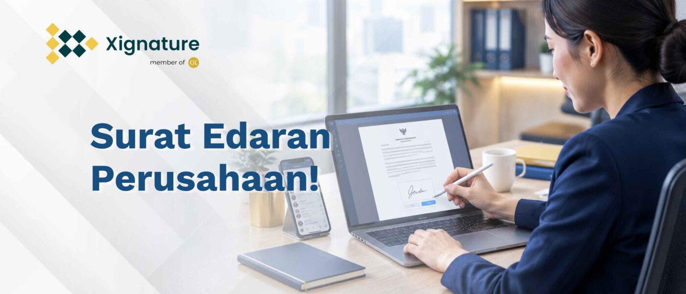 Staf HR menandatangani contoh surat edaran perusahaan secara digital di laptop, dengan ponsel berisi grup chat di sampingnya